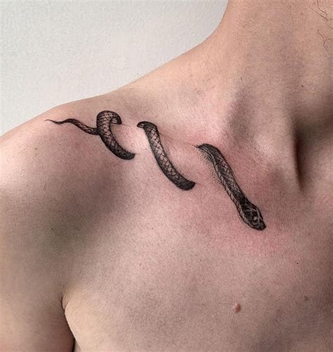 snake wrapped around collarbone tattoo.